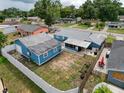 Birds eye view of blue home and detached garage with spacious backyard, and a cozy patio setup at 2214 Elise Marie Dr, Seffner, FL 33584