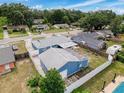 Aerial shot of a blue house with fenced backyard, neighboring homes, and lush green trees at 2214 Elise Marie Dr, Seffner, FL 33584