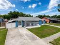 Quaint blue single-story home featuring a screened porch and a driveway extending to a fenced area at 2214 Elise Marie Dr, Seffner, FL 33584