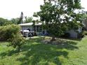 The backyard shows a well maintained lawn, mature trees, and a partially covered patio at 2787 Jay Pl, Sarasota, FL 34235