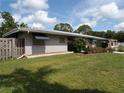 Lovely single-story home boasts a metal roof, awning-shaded windows, and lush green lawn at 2787 Jay Pl, Sarasota, FL 34235