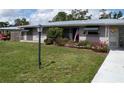 Attractive single-story home featuring a metal roof, awning-covered windows and flowering bushes at 2787 Jay Pl, Sarasota, FL 34235