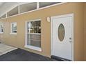 Home entrance features a secure white door, a window, and a light fixture providing a welcoming entry at 2820 Greenbriar St, Sarasota, FL 34237