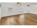 Bright and spacious living room featuring hardwood floors, fans, and lots of natural light at 3328 Kingswood Dr, Sarasota, FL 34232