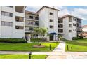 Beautiful condo featuring well-kept landscaping and a blue awning covered entryway at 3630 Gulf Of Mexico Dr # 202, Longboat Key, FL 34228