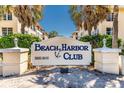 Attractive Beach Harbor Club entrance sign surrounded by well-maintained landscaping at 3806 Gulf Of Mexico Dr # C204, Longboat Key, FL 34228