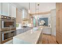 Modern kitchen with stone countertops, wood floors, stainless steel appliances and pendant lighting at 3921 Maravic Pl, Sarasota, FL 34231