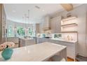 Bright kitchen with an island, pendant lighting, white countertops and cabinets, and stainless steel appliances at 3921 Maravic Pl, Sarasota, FL 34231