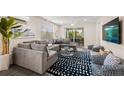 Comfortable living room featuring a gray sectional sofa, stylish rug, and sliding glass doors at 4321 Marina View Way, Cortez, FL 34215
