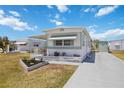 Charming single-story home showcasing a well-maintained lawn, concrete driveway, and landscaped flowerbeds at 5213 Bel Air Ave, Sarasota, FL 34234