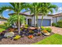 Beautiful home with well-manicured landscaping, palm trees, and a paver driveway leading to the garage at 5740 Eagle Creek Rd, Sarasota, FL 34238