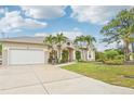 Charming single-story home with a lush lawn, palm trees and a spacious driveway at 5988 Viola Rd, Venice, FL 34293