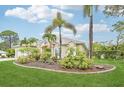 Beautiful house with lush landscaping, mature palm trees, and a well-kept lawn at 5988 Viola Rd, Venice, FL 34293