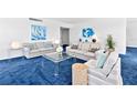 Inviting living room with comfortable sofas, a glass coffee table, and blue color accents at 601 Longboat Club Rd # 504S, Longboat Key, FL 34228
