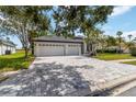 Charming home featuring lush landscaping, well-manicured lawn, and a spacious three-car garage at 6140 Bobby Jones Ct, Palmetto, FL 34221