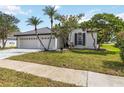 Charming home featuring lush landscaping, well-manicured lawn, and a spacious three-car garage at 6140 Bobby Jones Ct, Palmetto, FL 34221