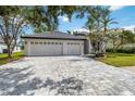 Charming home featuring lush landscaping, well-manicured lawn, and a spacious three-car garage at 6140 Bobby Jones Ct, Palmetto, FL 34221