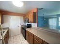Traditional kitchen with tile flooring, wooden cabinets, breakfast bar and black appliances at 6618 Kenwood Dr, North Port, FL 34287