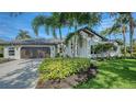 Beautiful home showcasing a well-maintained lawn, palm trees, a tile roof, and a large driveway at 6641 Saint James Xing, University Park, FL 34201