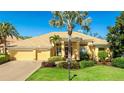 Beautiful single-story home boasting a well-manicured lawn, a light yellow exterior, and a terracotta-colored tile roof at 7081 Grassland Ct, Sarasota, FL 34241