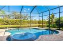 Tranquil screened-in pool and spa area featuring a fountain and views of the serene water and lush greenery at 7081 Grassland Ct, Sarasota, FL 34241
