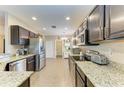 Spacious kitchen featuring dark wood cabinetry, stainless steel appliances, and granite countertops at 7410 61 E St, Palmetto, FL 34221