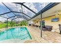 Relaxing screened-in pool area with a brick paved patio, outdoor furniture, and lush greenery at 7410 61 E St, Palmetto, FL 34221