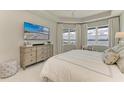Serene bedroom with large windows offering picturesque lake views, complemented by elegant furnishings at 909 Crosswind Ave, Sarasota, FL 34240