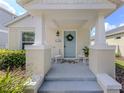 Close-up of the front porch with seating, a wreath, and the house number displayed above the light blue door at 12682 Shimmering Oak Cir, Venice, FL 34293