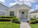 Inviting covered front porch featuring a light blue front door with a wreath and decorative landscaping at 12682 Shimmering Oak Cir, Venice, FL 34293