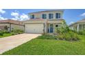 Charming two-story home with a well-manicured lawn, shutters, and a two-car garage at 12708 Aquamarine Ave, Bradenton, FL 34211