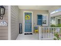 Inviting front porch featuring a vibrant blue door with a welcoming wreath and seating area at 12708 Aquamarine Ave, Bradenton, FL 34211