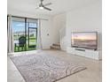 Open living room with tile floor, ceiling fan, large windows, and sliding glass door to the outdoors at 14835 Lyla Ter, Bradenton, FL 34211