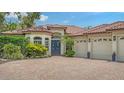 Beautiful exterior with a brick driveway, barrel tile roof, lush landscaping and three-car garage at 1864 Goldenrod St, Sarasota, FL 34239