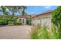 Beautiful exterior with a brick driveway, barrel tile roof, lush landscaping and three-car garage at 1864 Goldenrod St, Sarasota, FL 34239