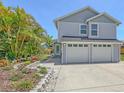 Charming two-story home features a manicured lawn, a two-car garage, and lovely landscaping at 2420 Webber St, Sarasota, FL 34239