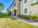 Townhome featuring manicured lawn and landscaping, covered entryway and two-car garage at 30073 Southwell Ln, Wesley Chapel, FL 33543