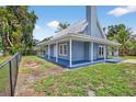 Charming blue home features a metal roof, wrap-around porch, and neat landscaping at 3320 19Th Street E Ct, Bradenton, FL 34208