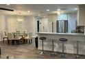 Open-concept kitchen with stainless steel appliances and breakfast bar connected to dining area at 4441 Groveland Ave, Sarasota, FL 34231