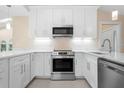 Bright, updated kitchen with modern stainless steel appliances and sleek white cabinetry at 4472 Calle Serena, Sarasota, FL 34238