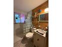 Quirky bathroom with glass block shower, bamboo accent wall, and vintage-style fixtures at 5011 Elfrida Ave, Sarasota, FL 34235