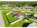 A high angle aerial view of a fenced-in property with lush green grass and nearby waterfront homes at 5200 Malaga Ave, Sarasota, FL 34235