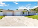 A lovely home featuring a long driveway, two-car garage, and a lush green front yard at 5200 Malaga Ave, Sarasota, FL 34235