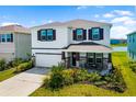 Beautiful two-story home with a well-manicured lawn, a covered porch, and a two-car garage at 5644 Flagstone Trl, Palmetto, FL 34221