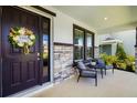 Inviting front porch with stone accents, a wreath-adorned door, and cozy seating area at 5644 Flagstone Trl, Palmetto, FL 34221