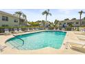 Inviting community pool with lounge chairs, umbrellas and white fencing at 6310 Green Oak Cir, Bradenton, FL 34203