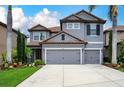 Charming two-story home featuring a gray stucco exterior, red tile roof, and meticulously landscaped front yard at 7020 Island Queen Ct, Sarasota, FL 34233