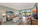 Charming living room featuring ample seating, stylish decor, and a view of the outdoors through sliding glass doors at 7461 W Country Club N Dr # 203, Sarasota, FL 34243