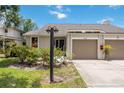 Inviting home exterior with attached garage, professional landscaping with flowering shrubs, and lush green lawn at 7926 Woodpointe Ct # 29, Sarasota, FL 34238