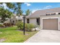 Charming home exterior featuring verdant lawn with flowering shrubs, mature trees and a private garage at 7926 Woodpointe Ct # 29, Sarasota, FL 34238